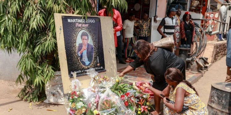 Mourners place a candles and flowers in the courtyard of Radio Amplitude FM, during a tribute ceremony for journalist Martinez Zogo, in the Elig Essono district of Yaounde on January 23, 2023. - A popular Cameroon radio journalist who had been missing following what a media rights group called an abduction has been found dead, his employer and police said on January 22, 2023.
Martinez Zogo was managing director of Yaounde-based private radio station Amplitude FM and the star host of a popular daily programme, Embouteillage (Gridlock).
On the air, the 51-year-old regularly tackled cases of corruption, not hesitating to question important personalities by name. (Photo by Daniel Beloumou Olomo / AFP)