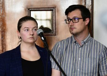 American couple Nicholas Spencer and his wife, Mackenzie Leigh Mathias Spencer, both 32, stand in the dock at Buganda road court, where they were charged with torturing a ten year old John Kayima and state prosecutor objected to their application saying that the two have been illegally in Uganda after their work permits expired, in Kampala, Uganda, December 14, 2022. REUTERS/Abubaker Lubowa
