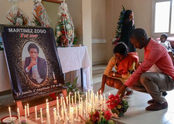 Mourners place candles in a room of Radio Amplitude FM where a portrait of journalist Martinez Zogo has been placed to pay tribute to him, in the Elig Essono district in Yaounde on January 23, 2023. A popular Cameroon radio journalist who had been missing following what a media rights group called an abduction has been found dead, his employer and police said on January 22, 2023.
Martinez Zogo was managing director of Yaounde-based private radio station Amplitude FM and the star host of a popular daily programme, Embouteillage (Gridlock).
On the air, the 51-year-old regularly tackled cases of corruption, not hesitating to question important personalities by name. (Photo by Daniel Beloumou Olomo / AFP)