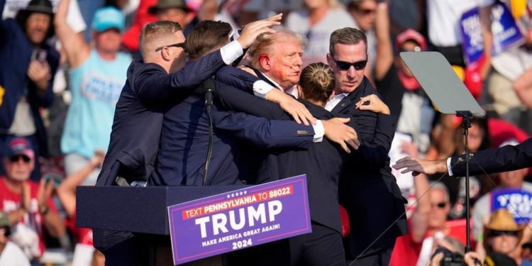 Republican presidential candidate former President Donald Trump is helped off the stage at a campaign event in Butler, Pa., Saturday, July 13, 2024. (AP Photo/Gene J. Puskar)