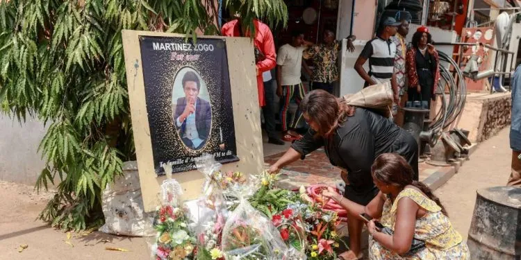 Mourners place a candles and flowers in the courtyard of Radio Amplitude FM, during a tribute ceremony for journalist Martinez Zogo, in the Elig Essono district of Yaounde on January 23, 2023. - A popular Cameroon radio journalist who had been missing following what a media rights group called an abduction has been found dead, his employer and police said on January 22, 2023.
Martinez Zogo was managing director of Yaounde-based private radio station Amplitude FM and the star host of a popular daily programme, Embouteillage (Gridlock).
On the air, the 51-year-old regularly tackled cases of corruption, not hesitating to question important personalities by name. (Photo by Daniel Beloumou Olomo / AFP)