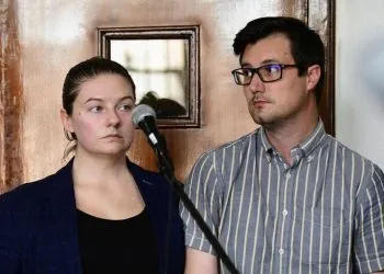 American couple Nicholas Spencer and his wife, Mackenzie Leigh Mathias Spencer, both 32, stand in the dock at Buganda road court, where they were charged with torturing a ten year old John Kayima and state prosecutor objected to their application saying that the two have been illegally in Uganda after their work permits expired, in Kampala, Uganda, December 14, 2022. REUTERS/Abubaker Lubowa