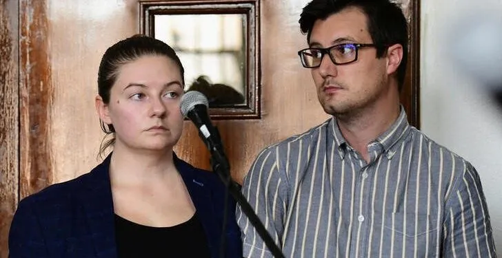 American couple Nicholas Spencer and his wife, Mackenzie Leigh Mathias Spencer, both 32, stand in the dock at Buganda road court, where they were charged with torturing a ten year old John Kayima and state prosecutor objected to their application saying that the two have been illegally in Uganda after their work permits expired, in Kampala, Uganda, December 14, 2022. REUTERS/Abubaker Lubowa