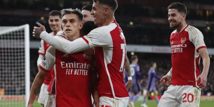 Arsenal's Belgian midfielder #19 Leandro Trossard (C) celebrates with teammates after scoring his team third goal during the English Premier League football match between Arsenal and Liverpool at the Emirates Stadium in London on February 4, 2024. (Photo by Ian Kington / IKIMAGES / AFP)