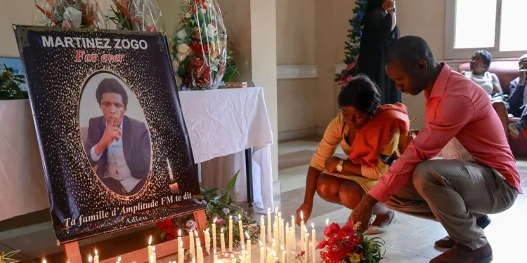 Mourners place candles in a room of Radio Amplitude FM where a portrait of journalist Martinez Zogo has been placed to pay tribute to him, in the Elig Essono district in Yaounde on January 23, 2023. A popular Cameroon radio journalist who had been missing following what a media rights group called an abduction has been found dead, his employer and police said on January 22, 2023.
Martinez Zogo was managing director of Yaounde-based private radio station Amplitude FM and the star host of a popular daily programme, Embouteillage (Gridlock).
On the air, the 51-year-old regularly tackled cases of corruption, not hesitating to question important personalities by name. (Photo by Daniel Beloumou Olomo / AFP)